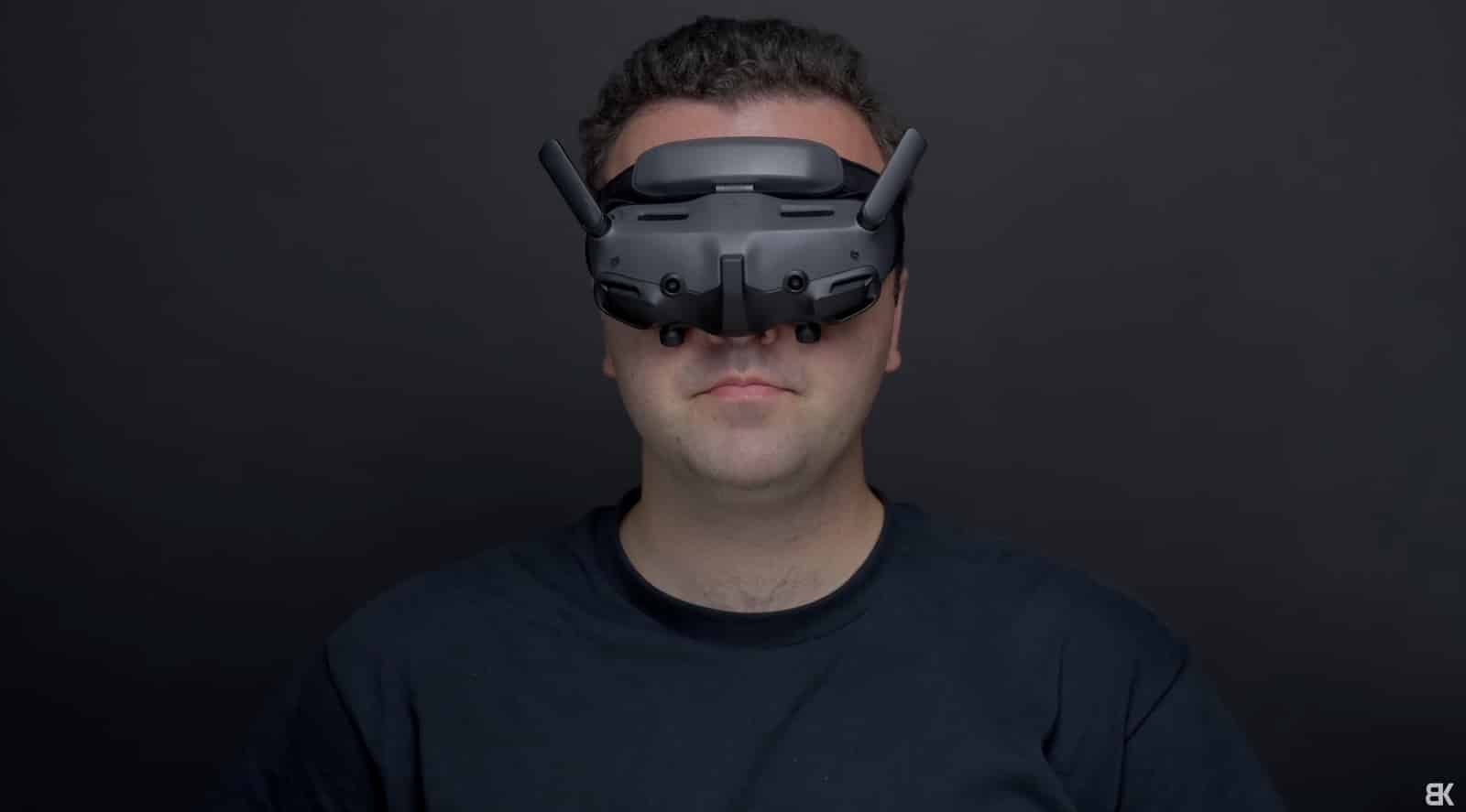 Billy Kyle wearing the DJI Goggles 3 against a dark studio backdrop.