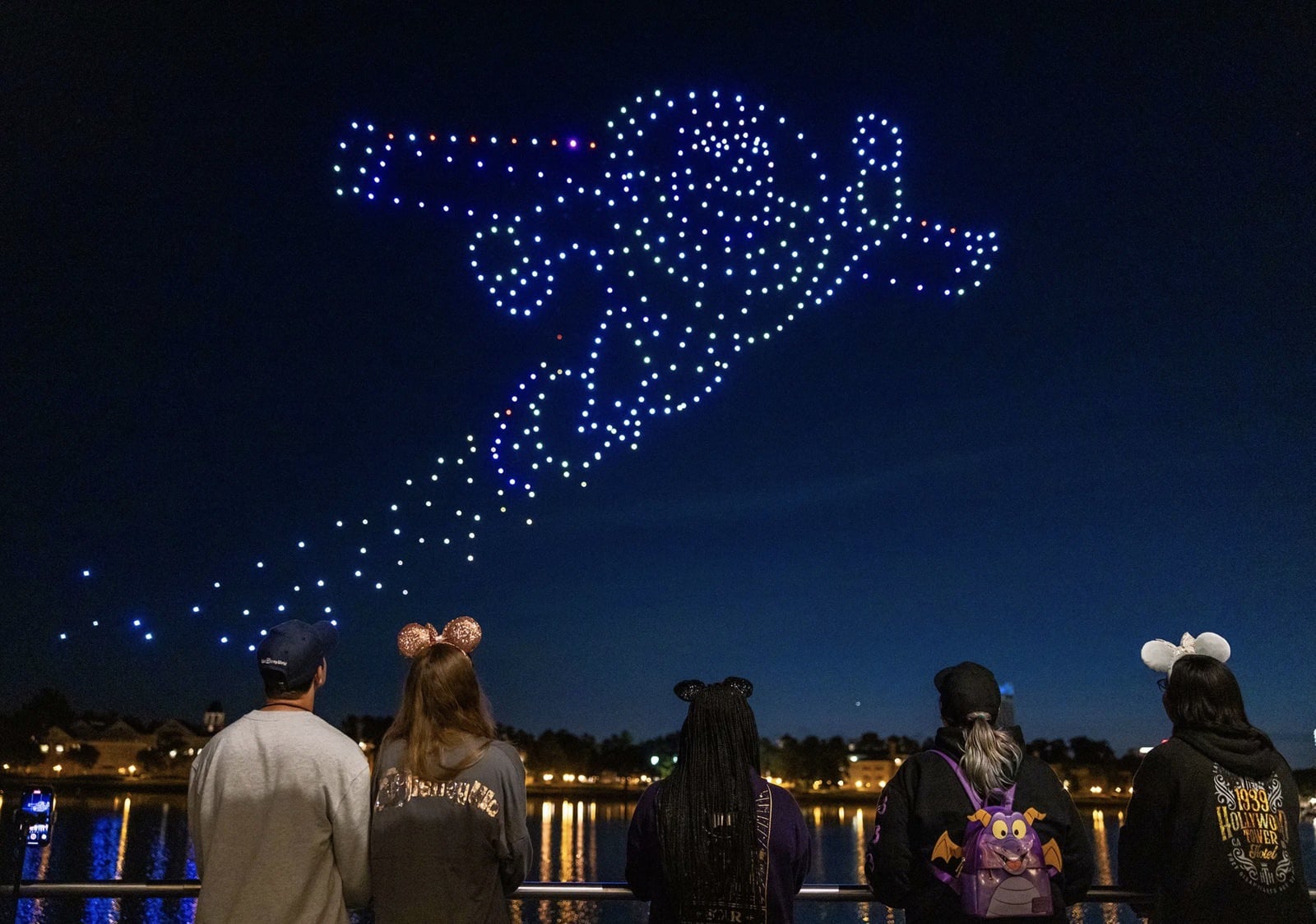 Peter Pan formed by drones over guests wearing light-up Mickey ears.