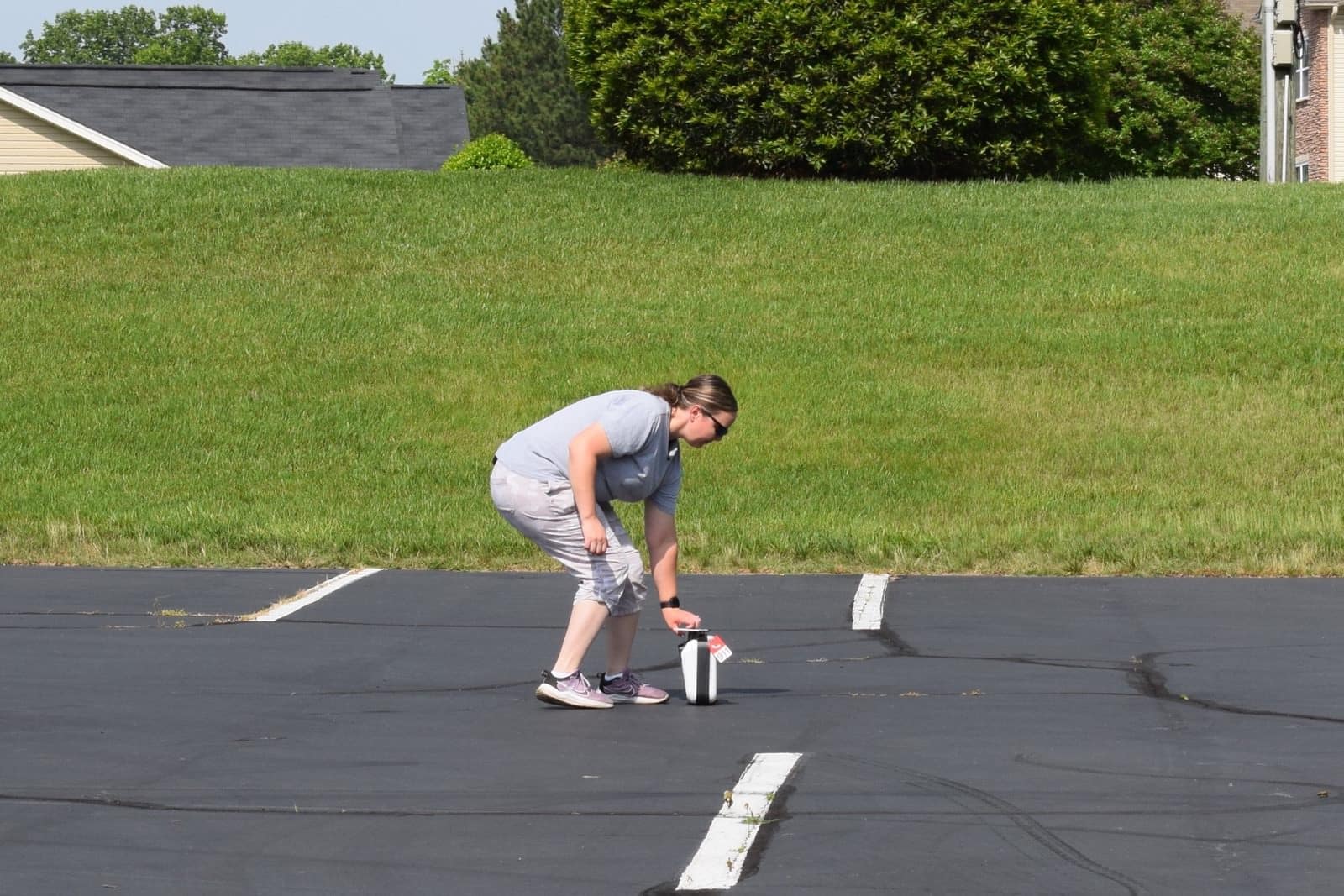 Responder picking up the drone-delivered defibrillator case from the parking lot.