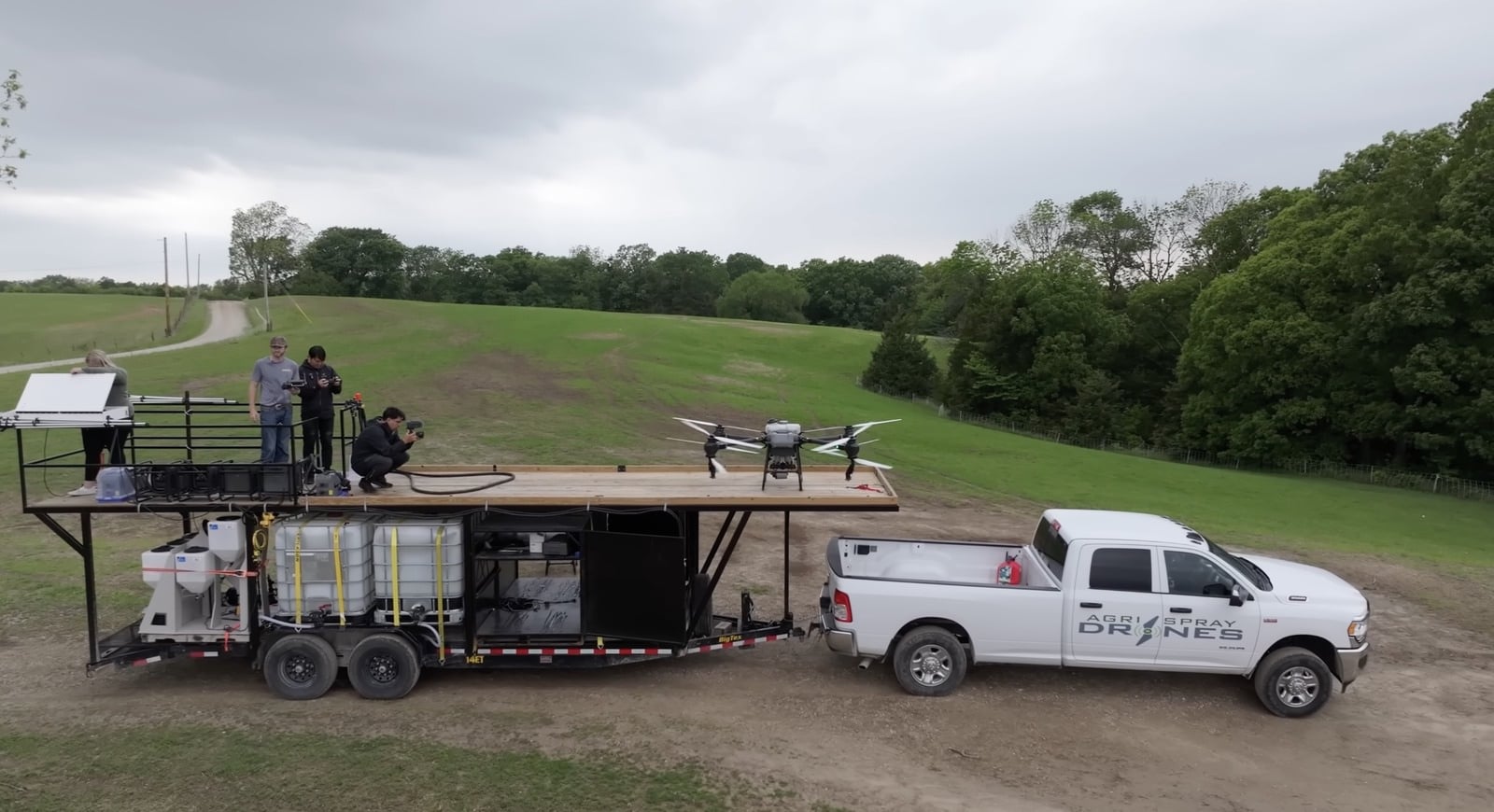 Agri Spray Drones trailer and white pickup with a FlyCart 30 parked on top.