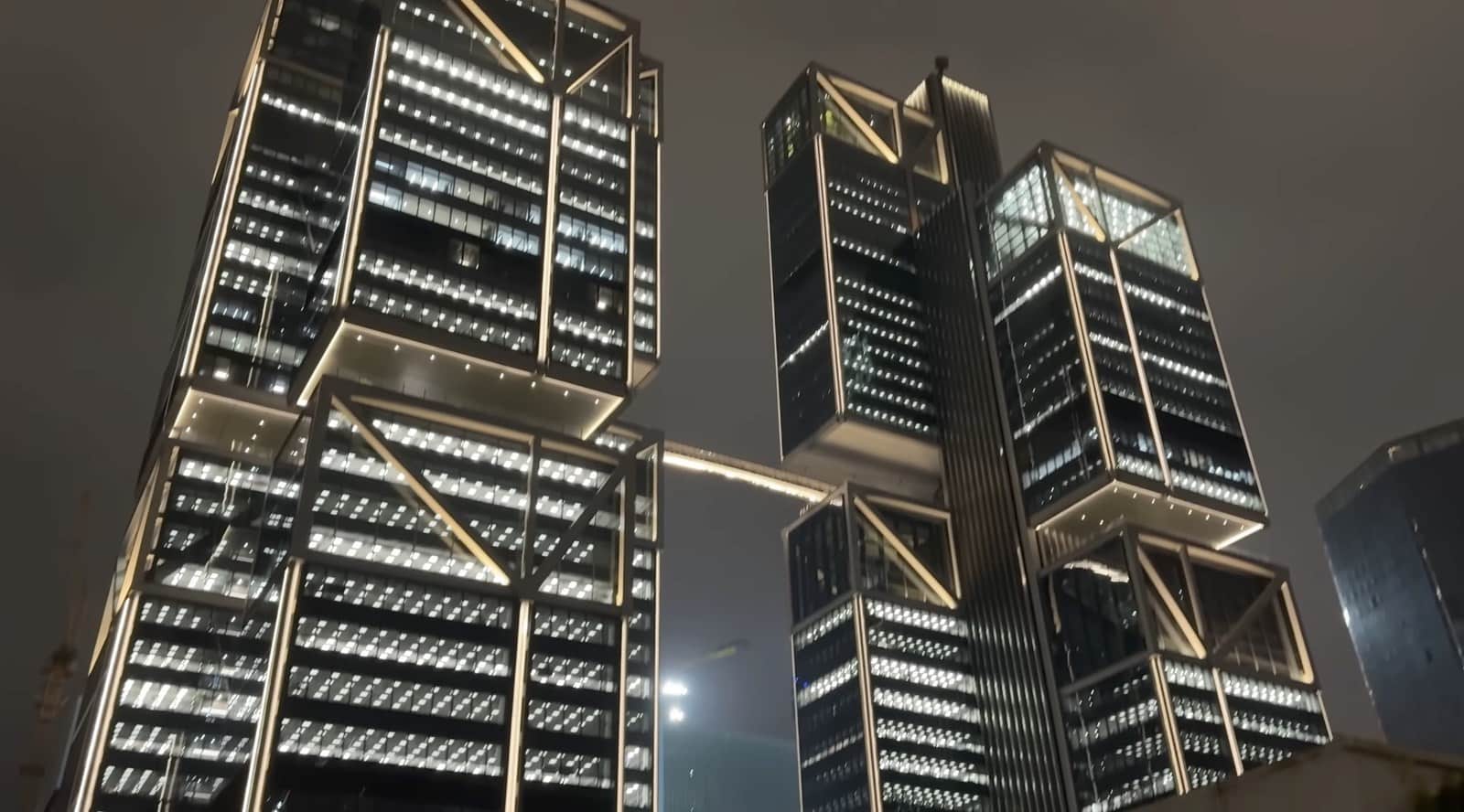 DJI headquarters towers in Shenzhen glowing at night with stacked glass blocks.