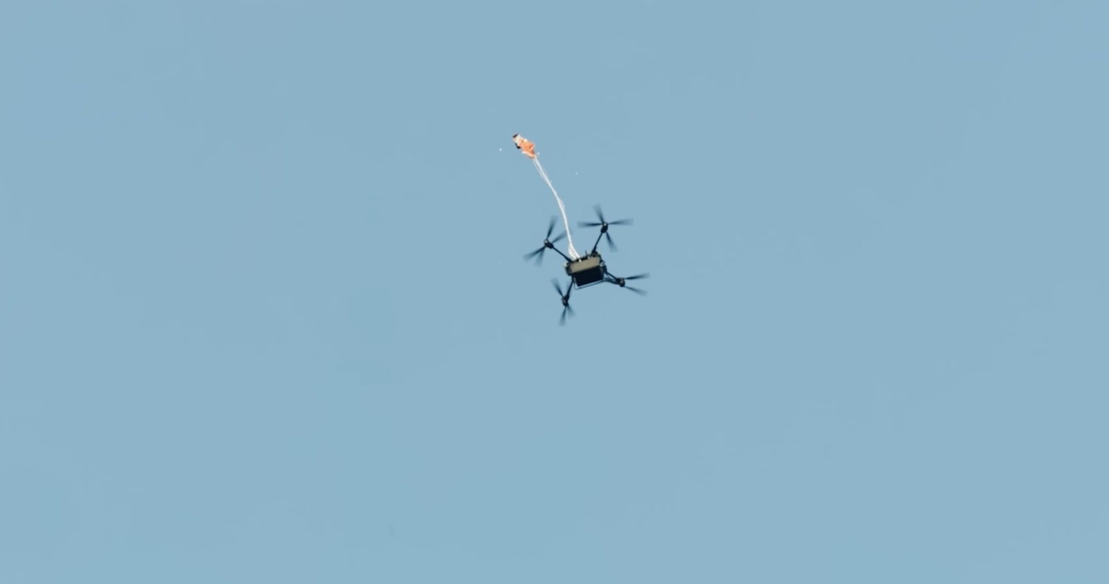 Parachute streaming out above the FlyCart 30 as it falls through blue sky.
