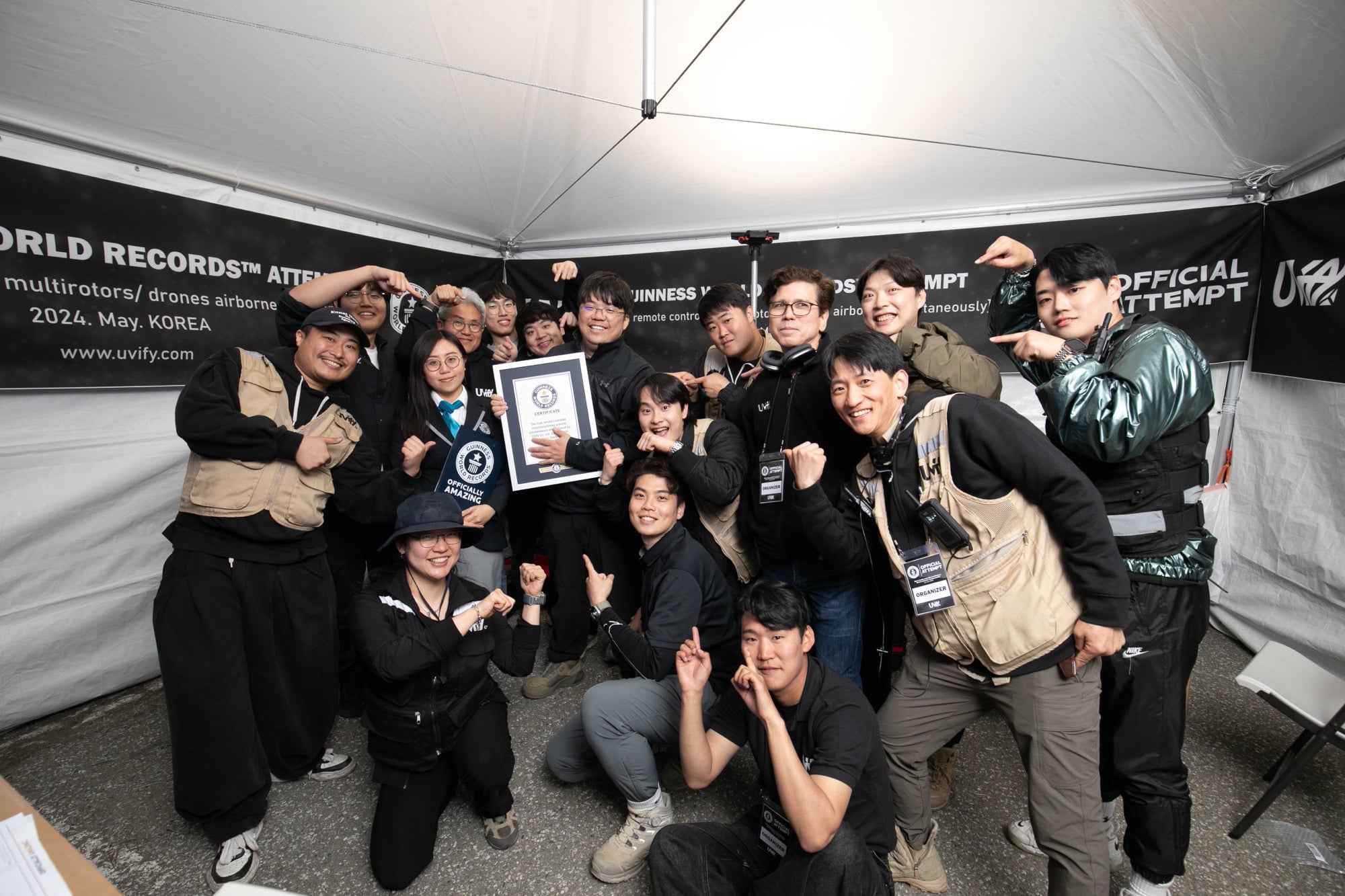 UVify crew celebrating under a tent with their Guinness World Records certificate.