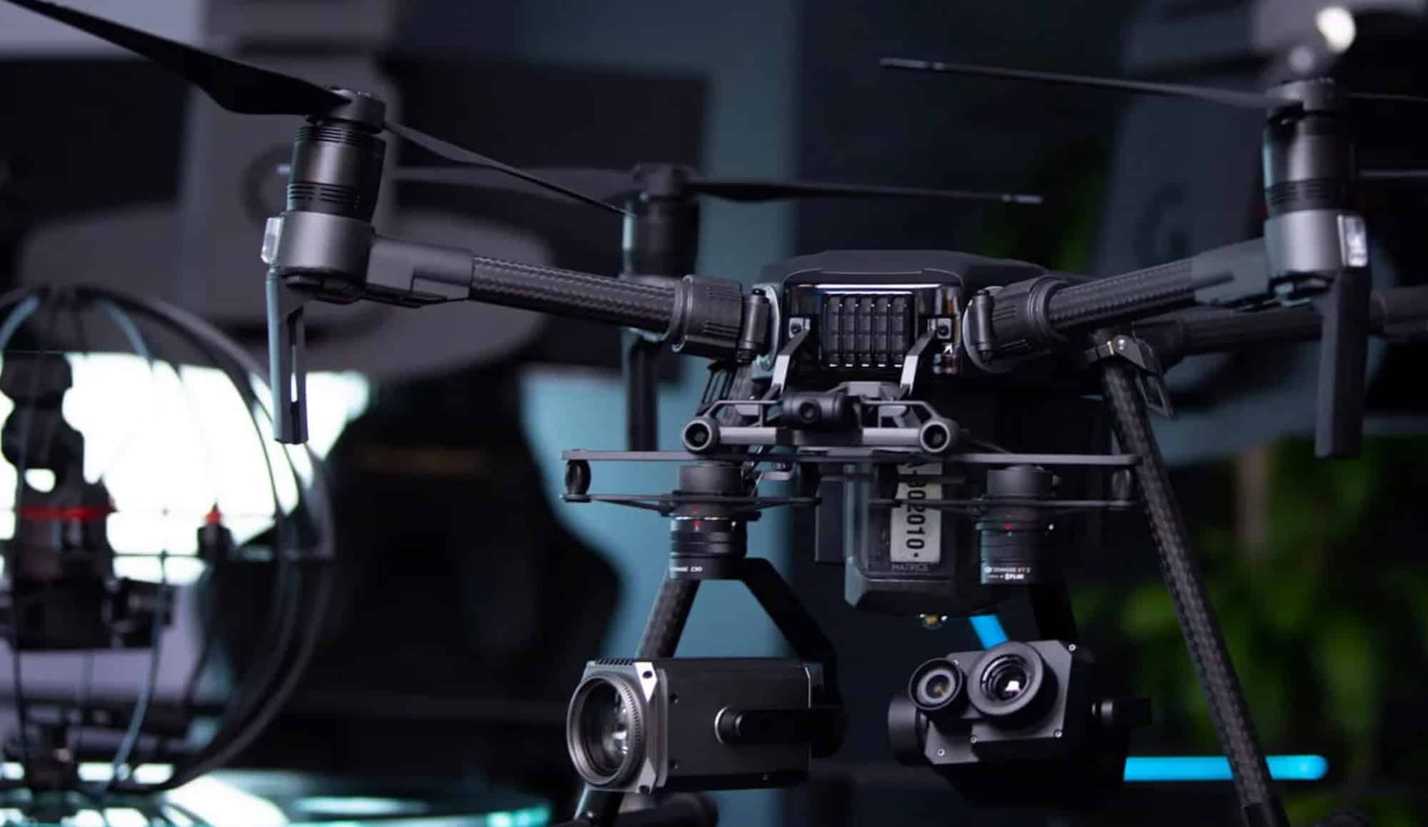 Black inspection quadcopter with gimbal sensors parked inside a workshop.