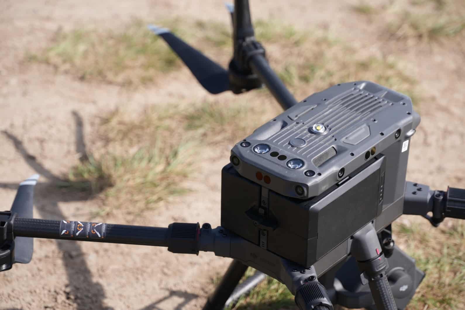 Close-up of the Lidar survey quadcopter resting on a dusty two-track road.