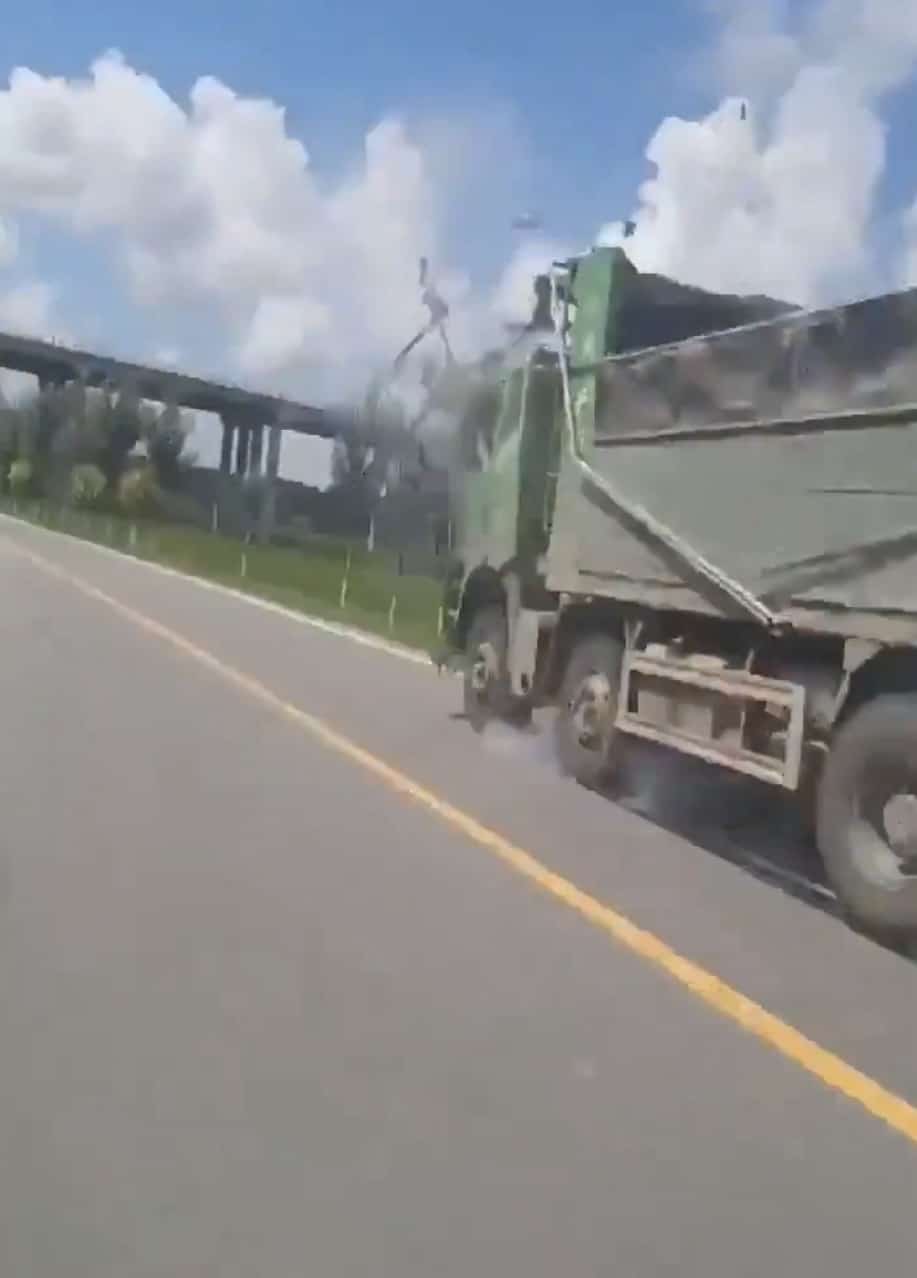 The drone striking the dump truck bed as debris scatters into the air.