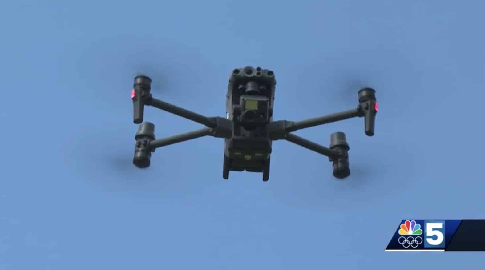 A large enterprise quadcopter climbs into clear blue sky in an NBC 5 report.