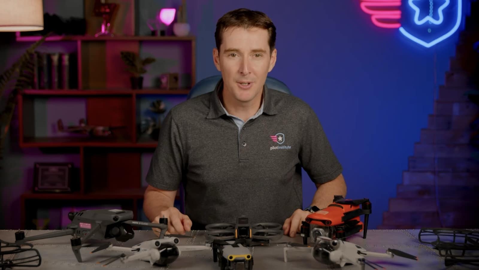 Greg Reverdiau of Pilot Institute behind a row of consumer drones on a desk.