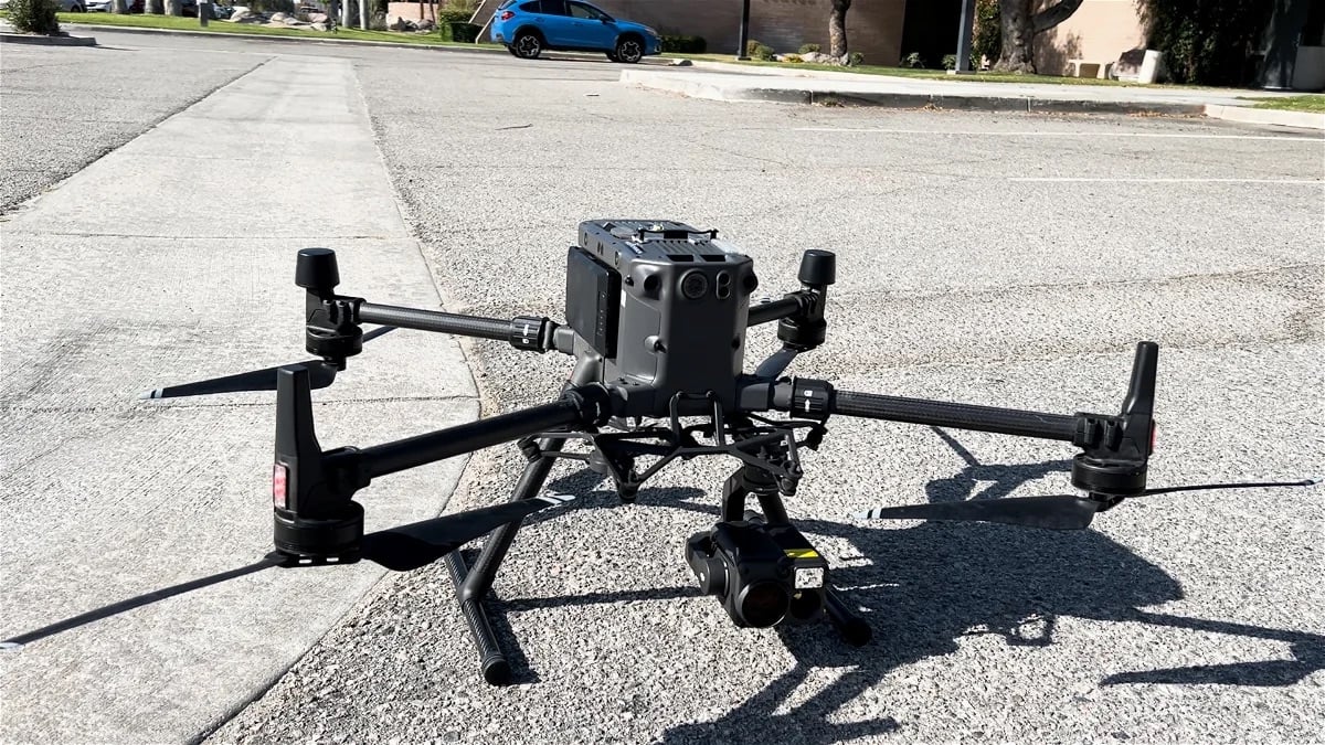 DJI Matrice 300 RTK standing on a parking lot with its gimbal camera below.
