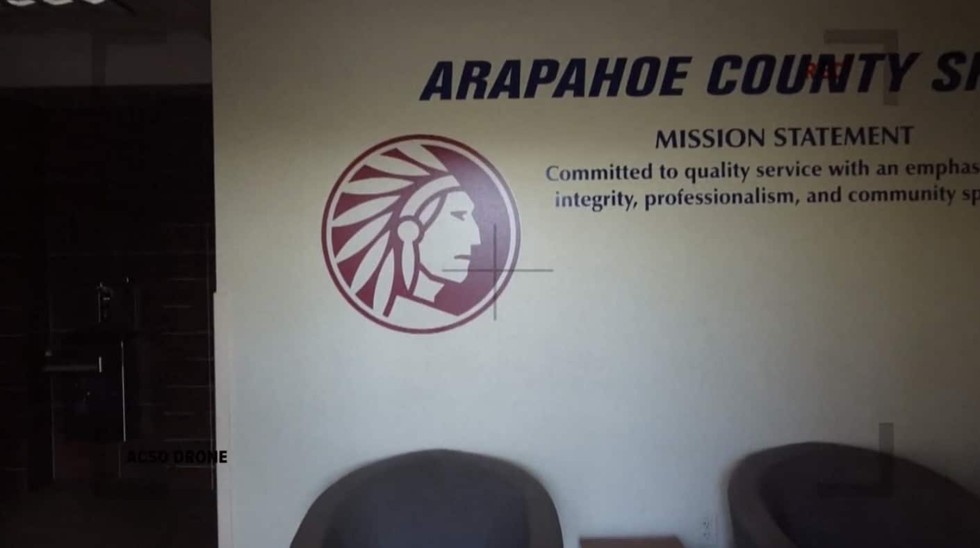 Drone camera view of the Arapahoe County Sheriff mission statement on a lobby wall.