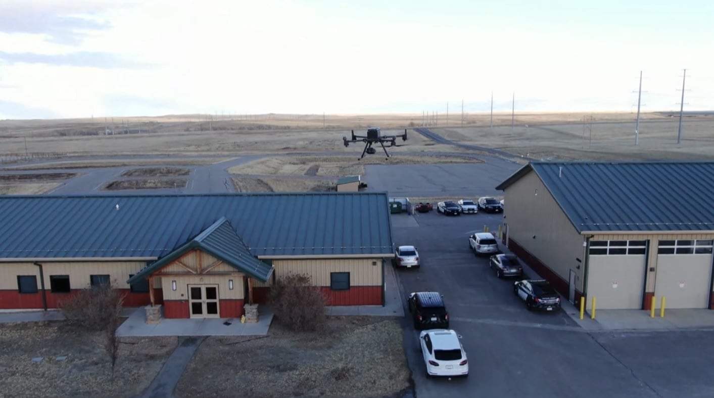 Aerial view of the sheriff substation and patrol cars with a drone overhead.