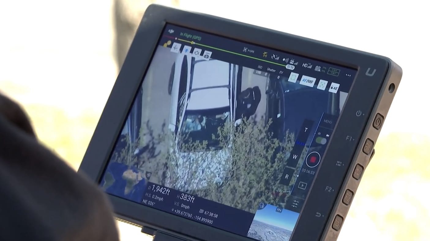 Rugged tablet controller displaying the drone view of a parked vehicle and brush.
