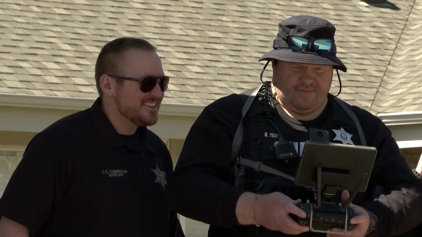 Two Arapahoe County deputies outside, one flying with a tablet-equipped controller.