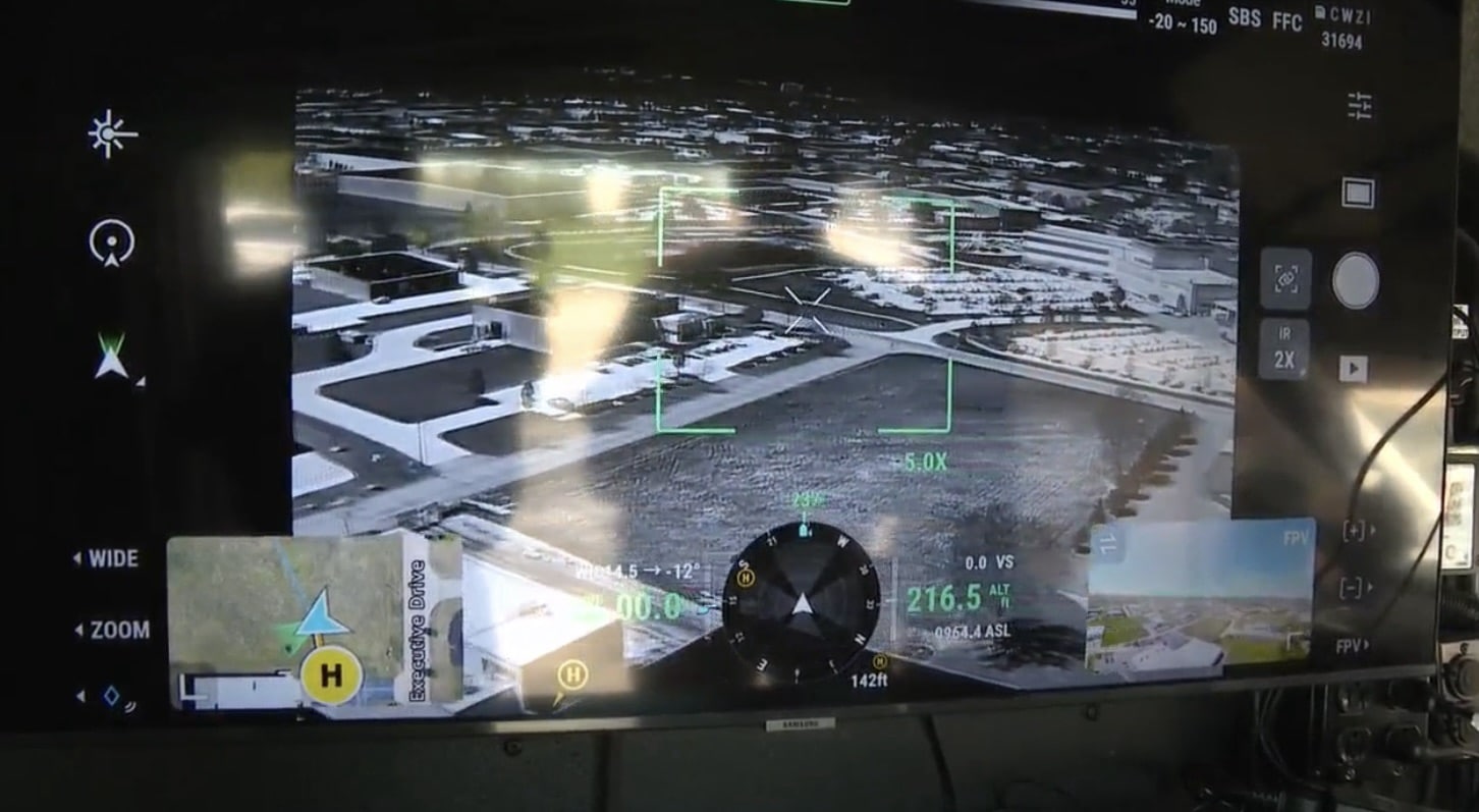 Controller screen showing a thermal aerial view of a parking lot with tracking boxes.