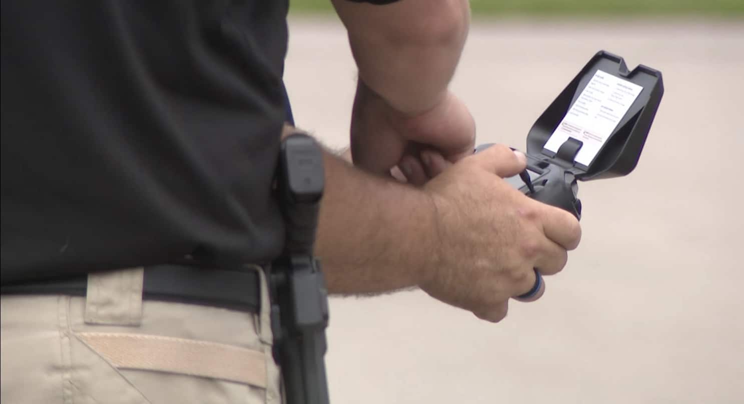 Close-up of a trainee hands on a DJI controller with a phone mounted.