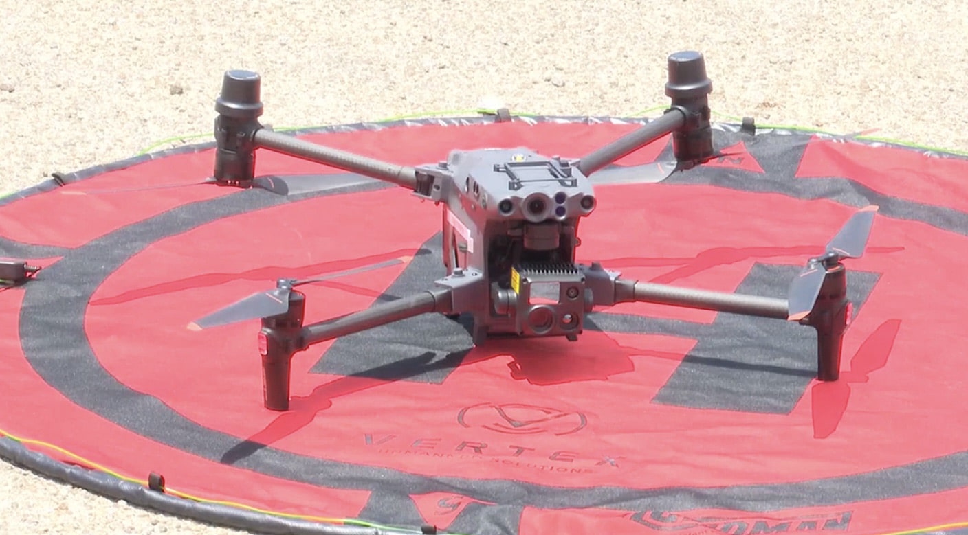Large DJI enterprise quadcopter waiting on a red and black landing pad.