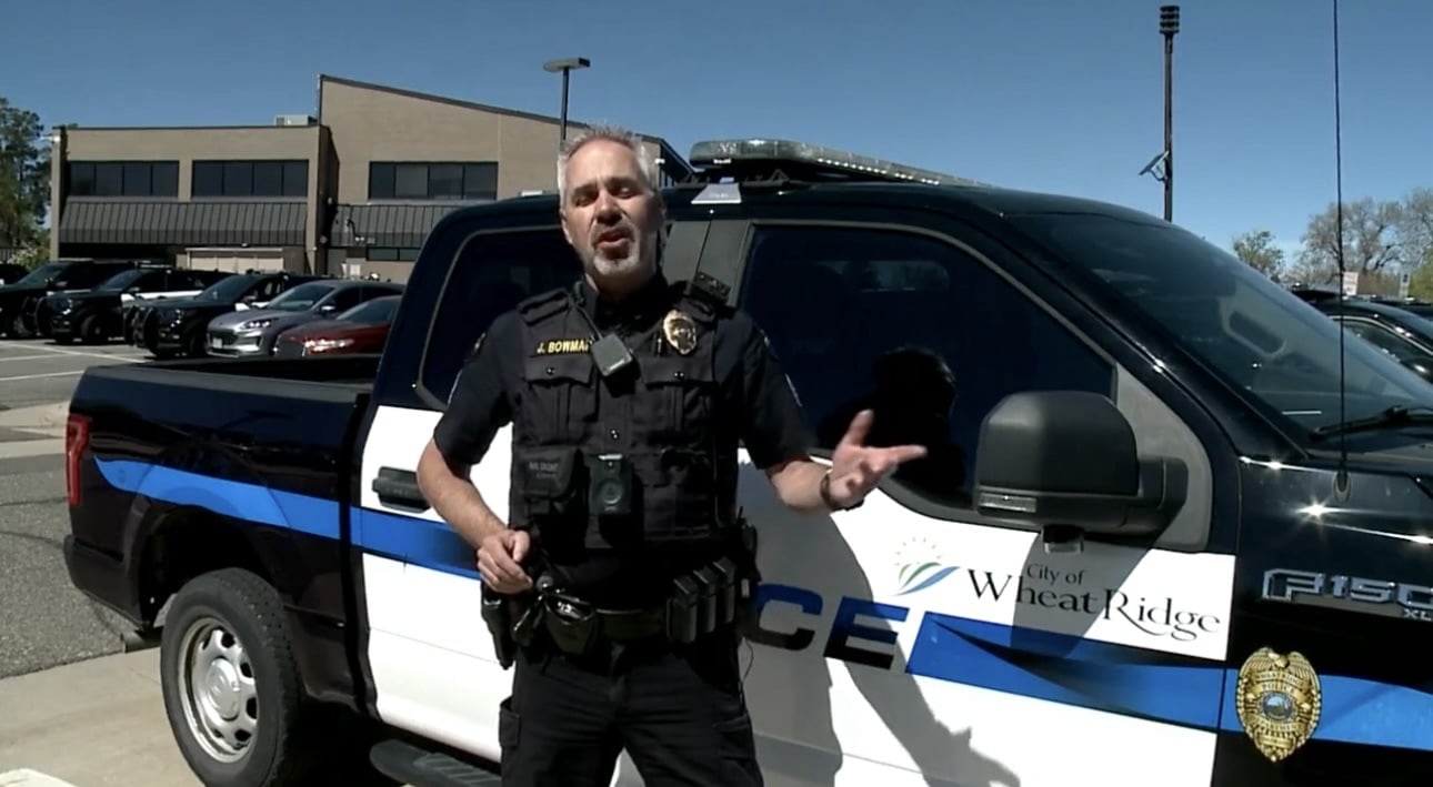 A Wheat Ridge police sergeant explains the program beside a department pickup truck.
