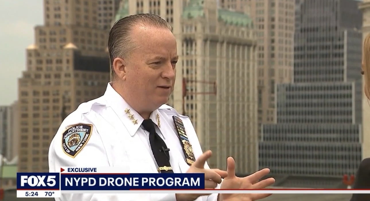 Screenshot of a senior NYPD officer being interviewed above Lower Manhattan.