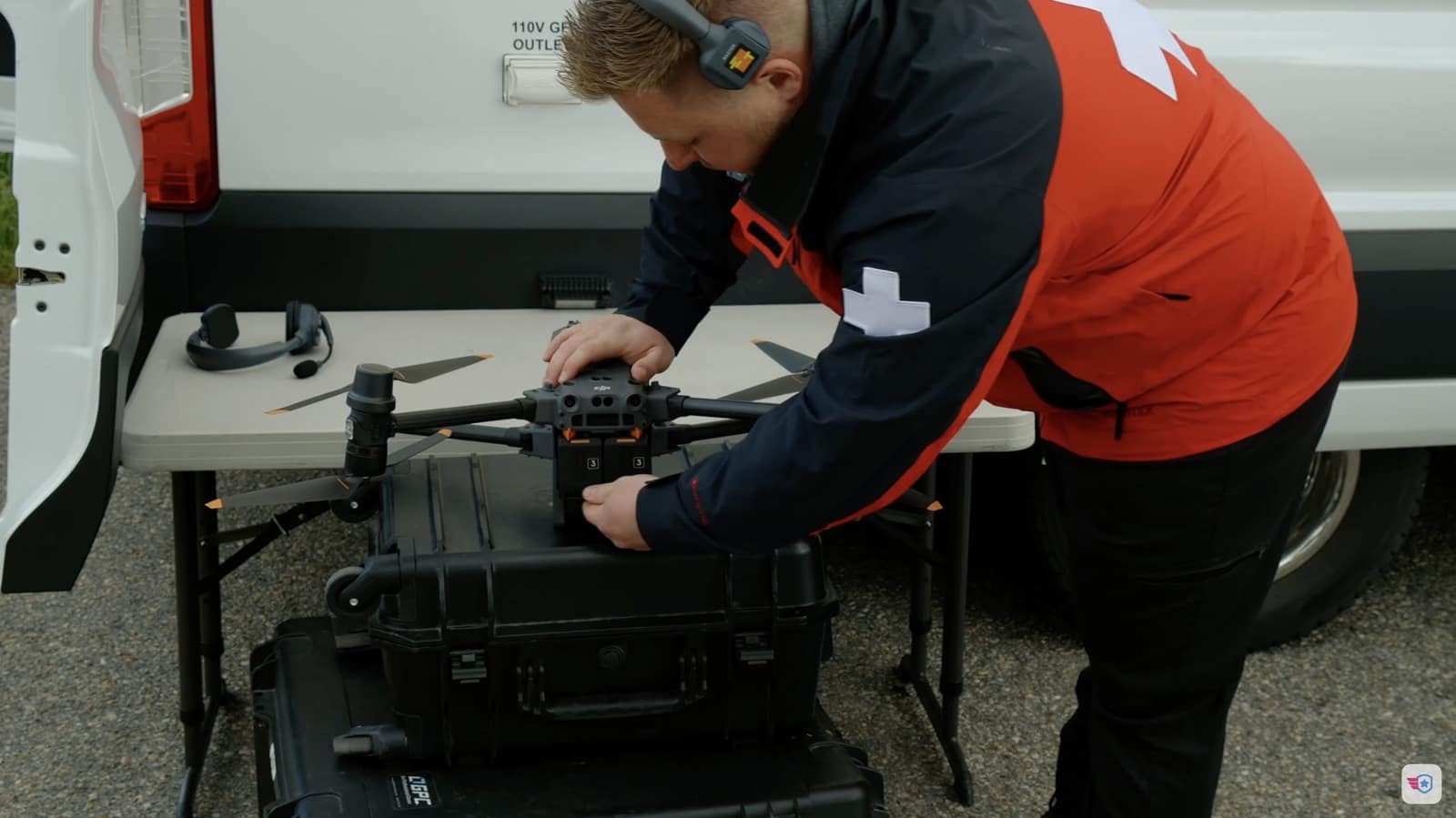 Search and rescue volunteer preparing a DJI Matrice on a table behind the command van.