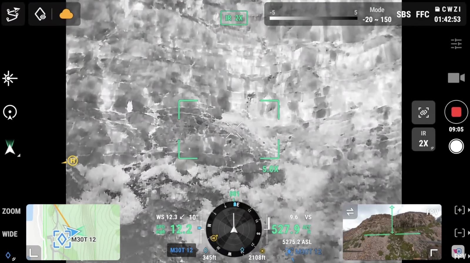 Thermal camera view of rocky terrain rendered in grayscale with zoom controls.