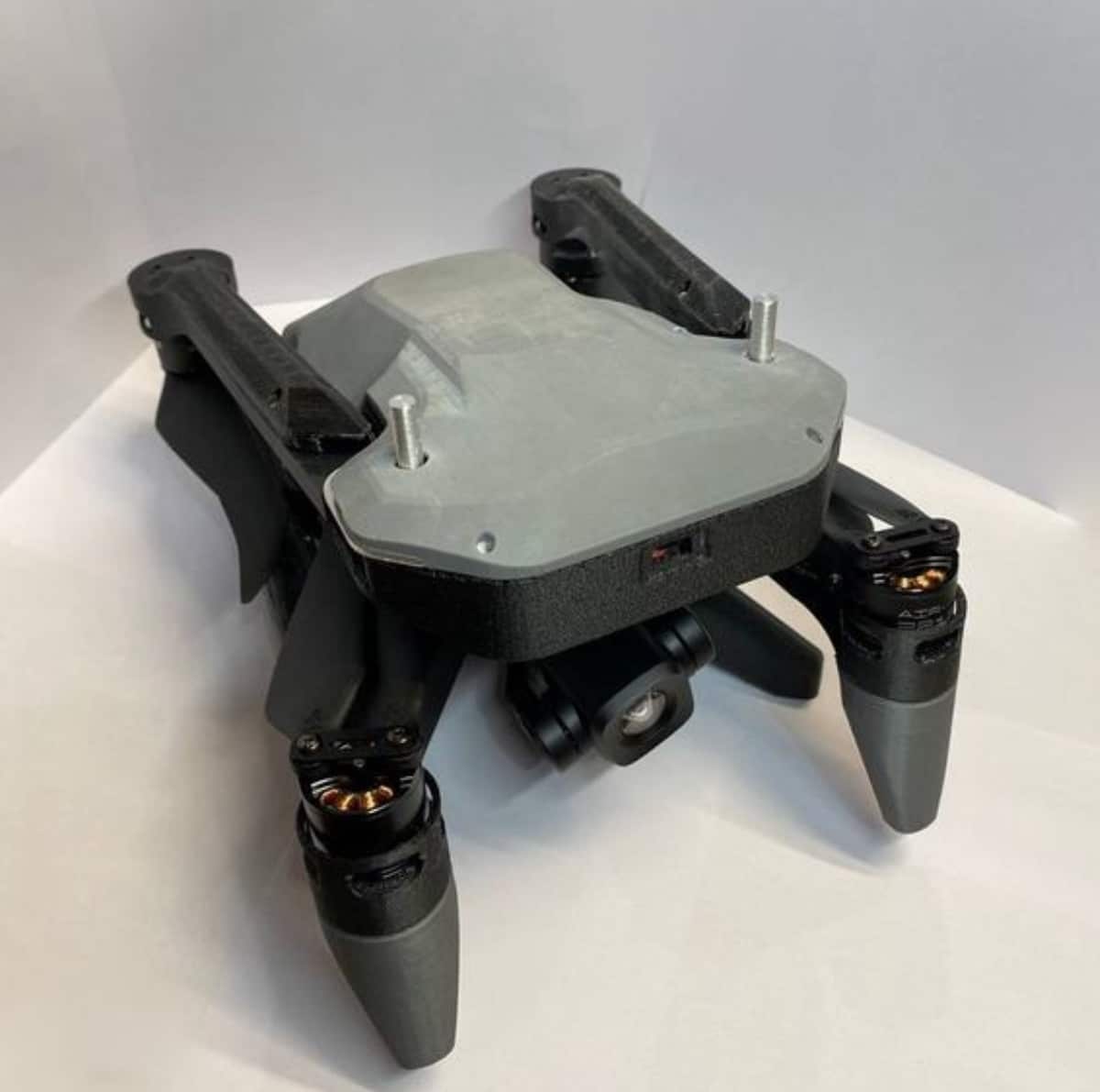 Grey and black Russian quadcopter shown from above on a white surface.