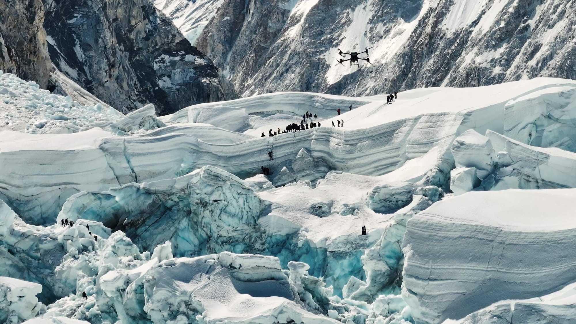 Delivery drone flying over the Khumbu Icefall as climbers cross the crevassed glacier.