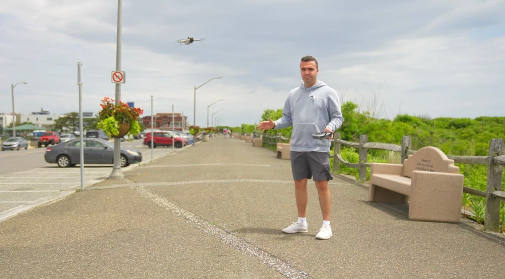 Billy Kyle flying a DJI Mini 4 Pro from a seaside boardwalk.