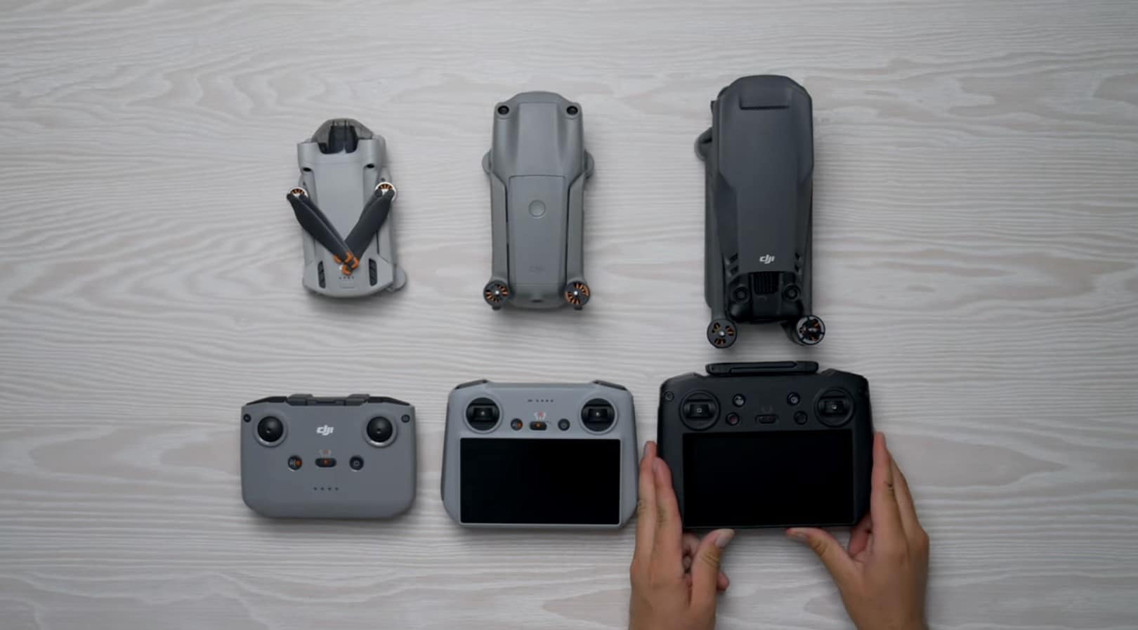 Three folding DJI drones lined up above their matching RC-N2, RC 2 and RC Pro.