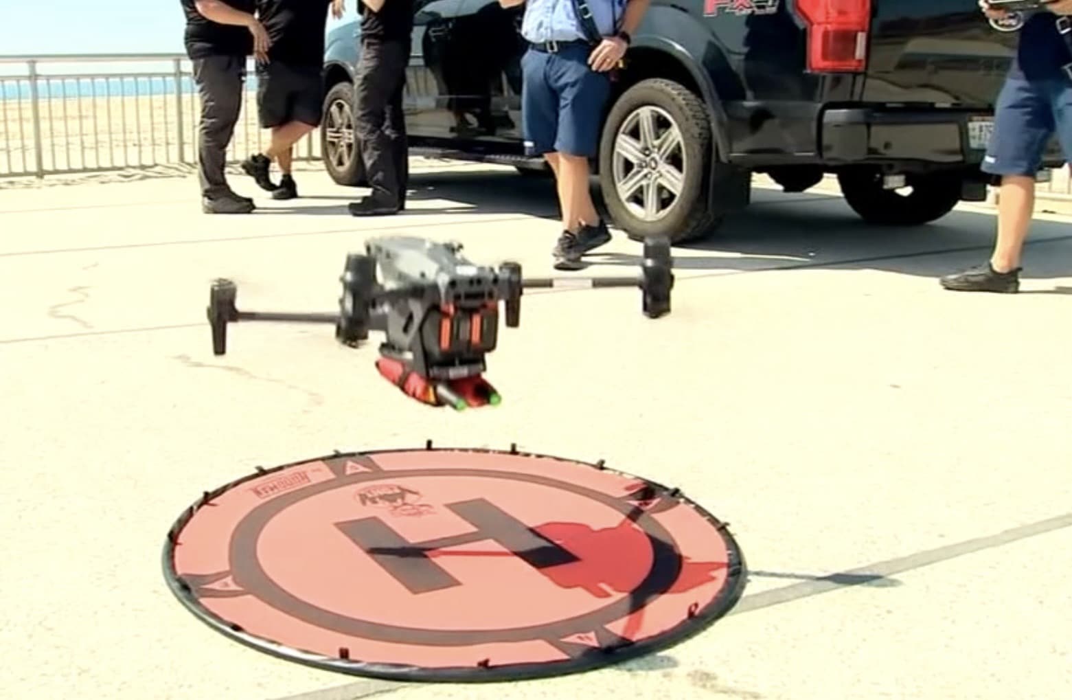 Matrice lifting off from the pavement next to an empty red H landing pad.