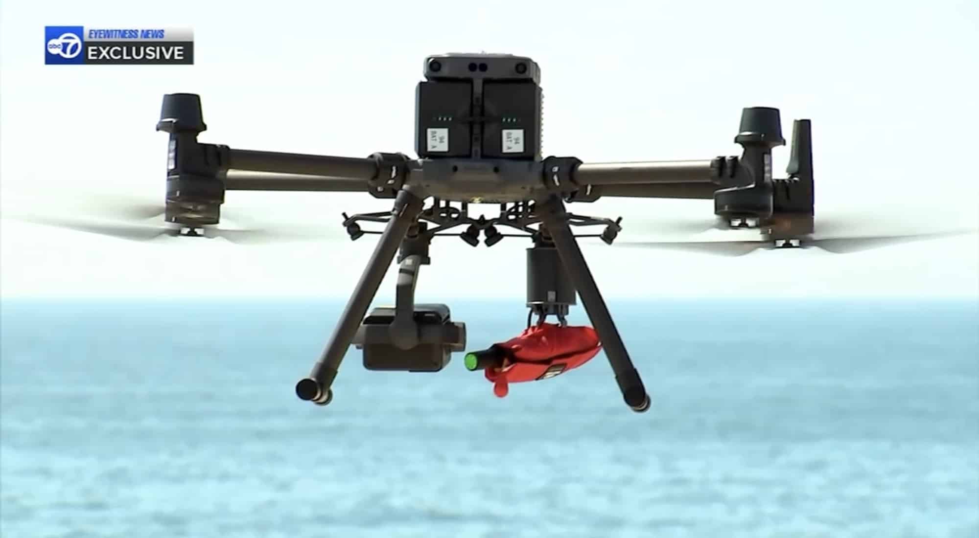 DJI Matrice hovering over the water with the red rescue float ready to release.