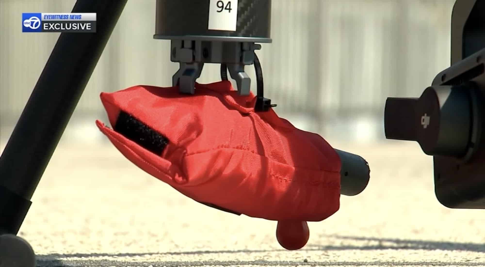 Red rescue float pack clipped to a drone release mechanism numbered 94.