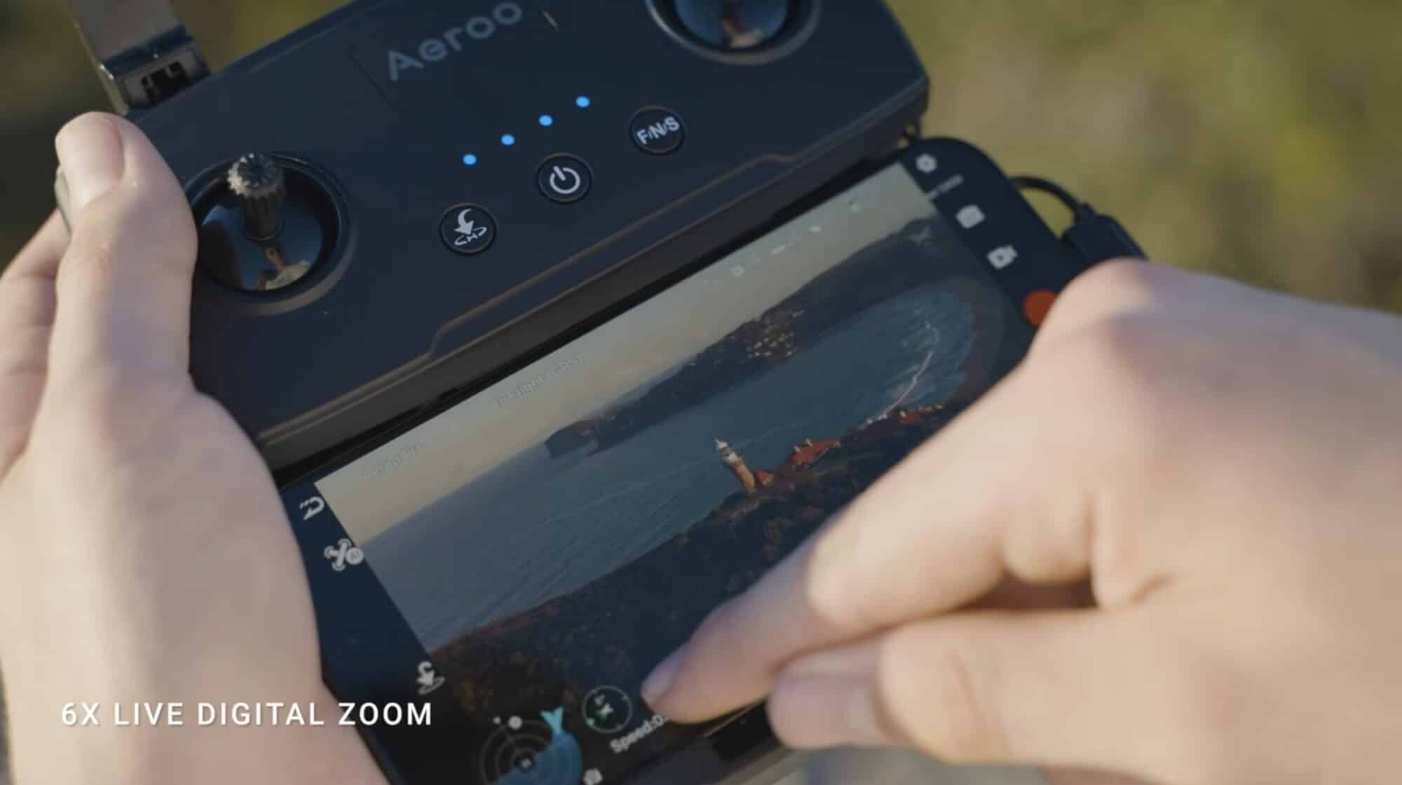 Hands on the Aeroo controller with a phone showing 6x live digital zoom.