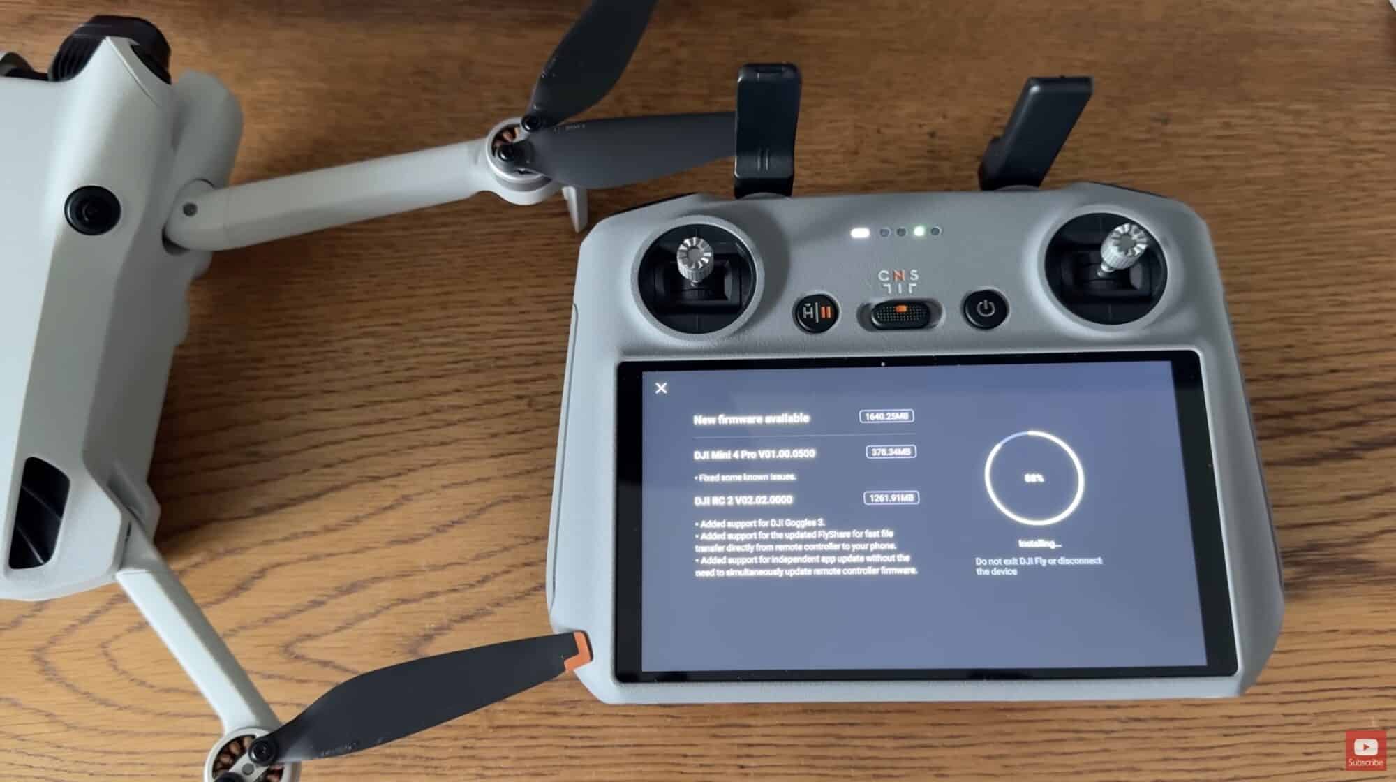 DJI RC 2 controller installing new firmware beside a folded DJI Mini 4 Pro.