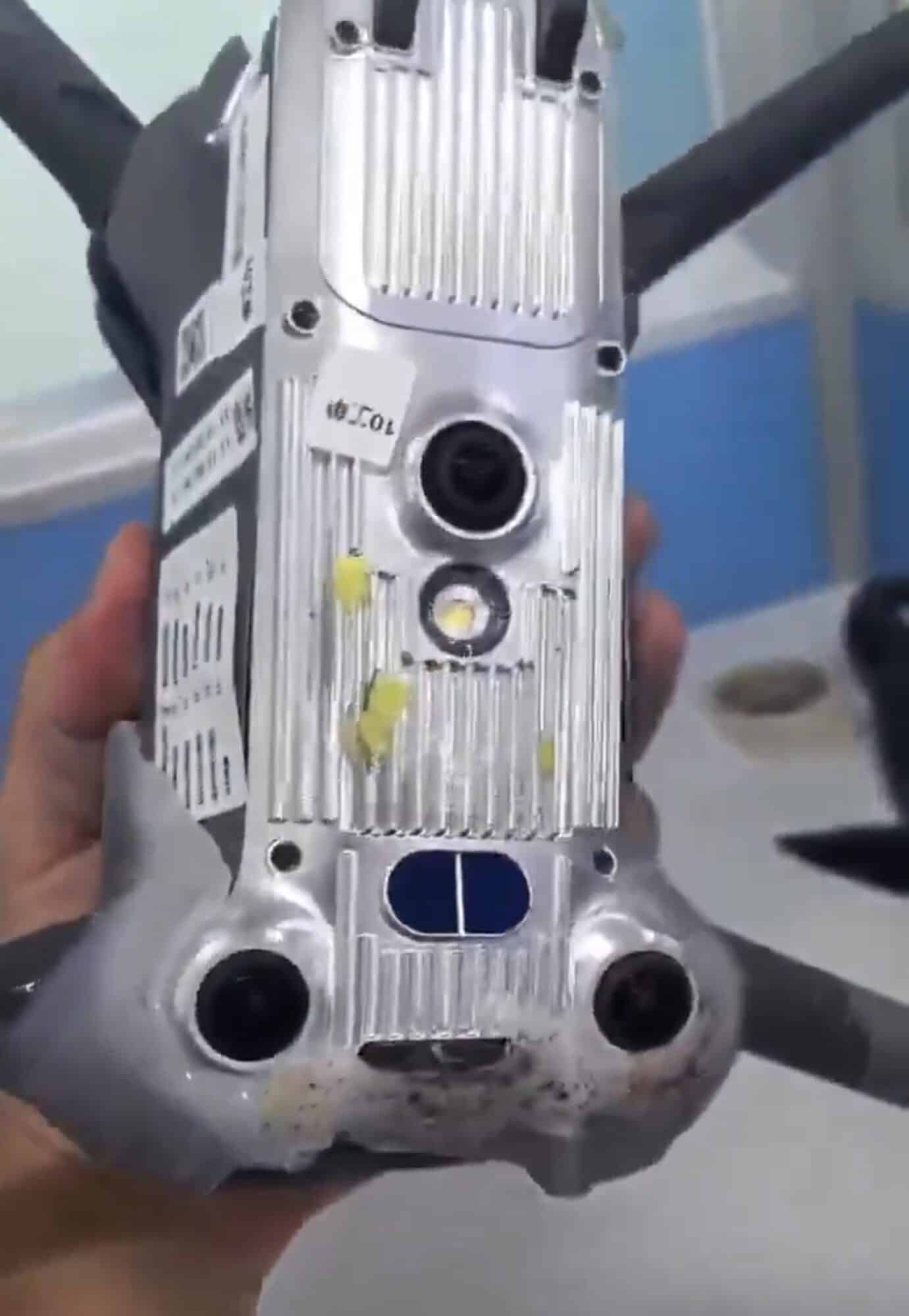 Belly of the drone from another angle with a blue-covered sensor window.