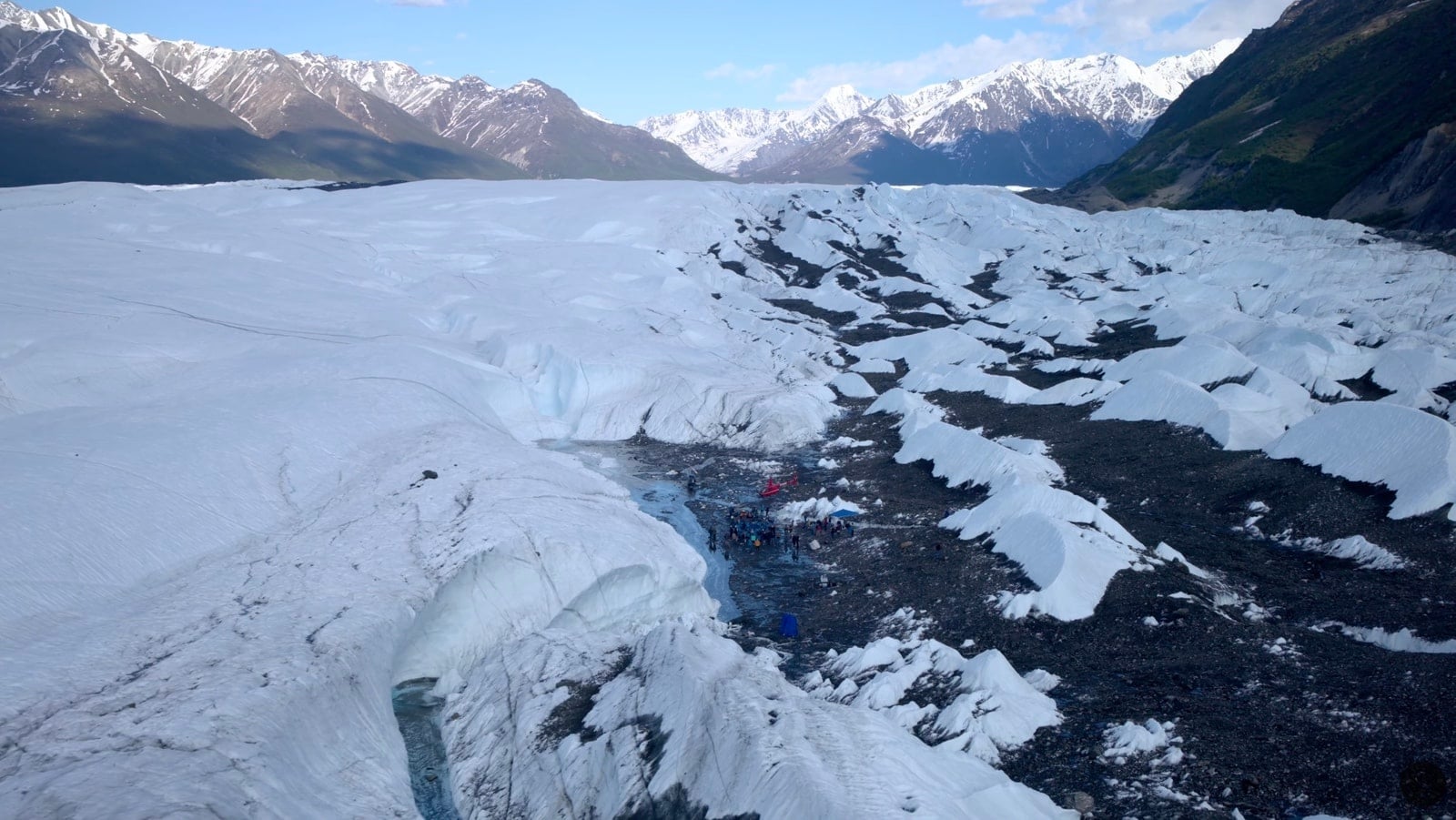 Aerial view of the crevassed glacier with the concert crowd far below.