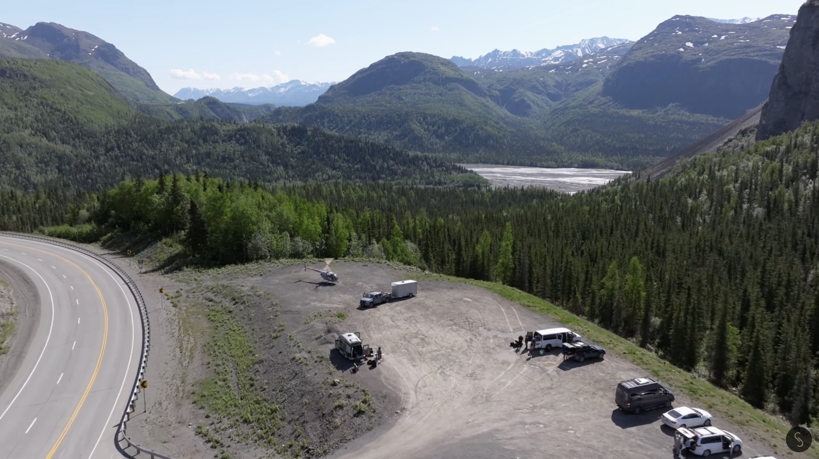 Aerial view of the highway staging area where crew vehicles parked among spruce.