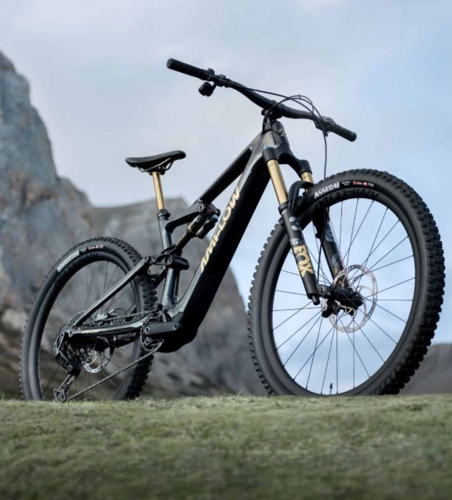 Side view of the black and gold Amflow full-suspension electric mountain bike.