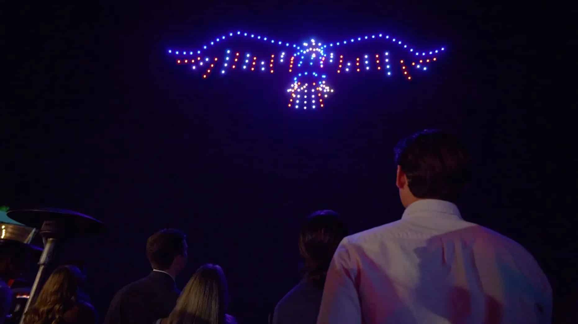 Spectators watch an eagle formed by red, white and blue drone lights.