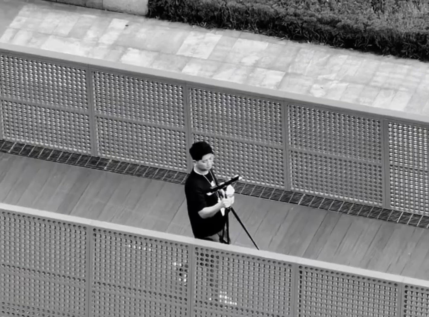 Tester in black holding a controller on a ramp beside perforated metal railings.