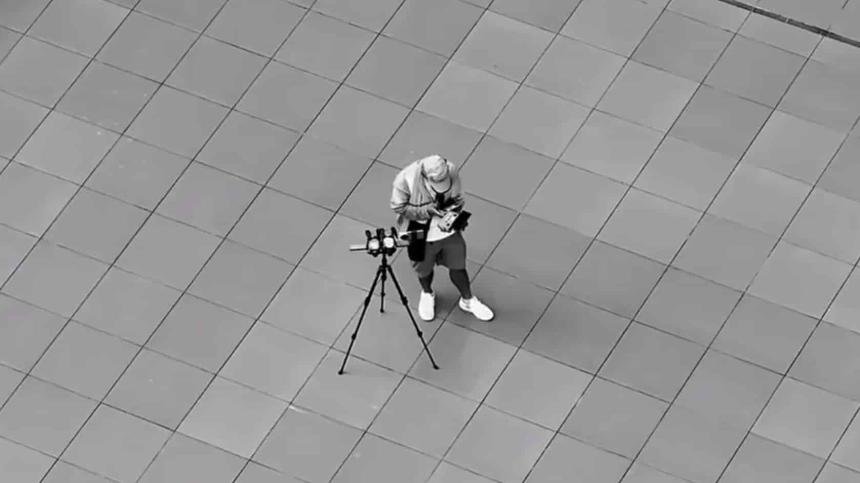 Tester working a controller next to the tripod rig on the open plaza.