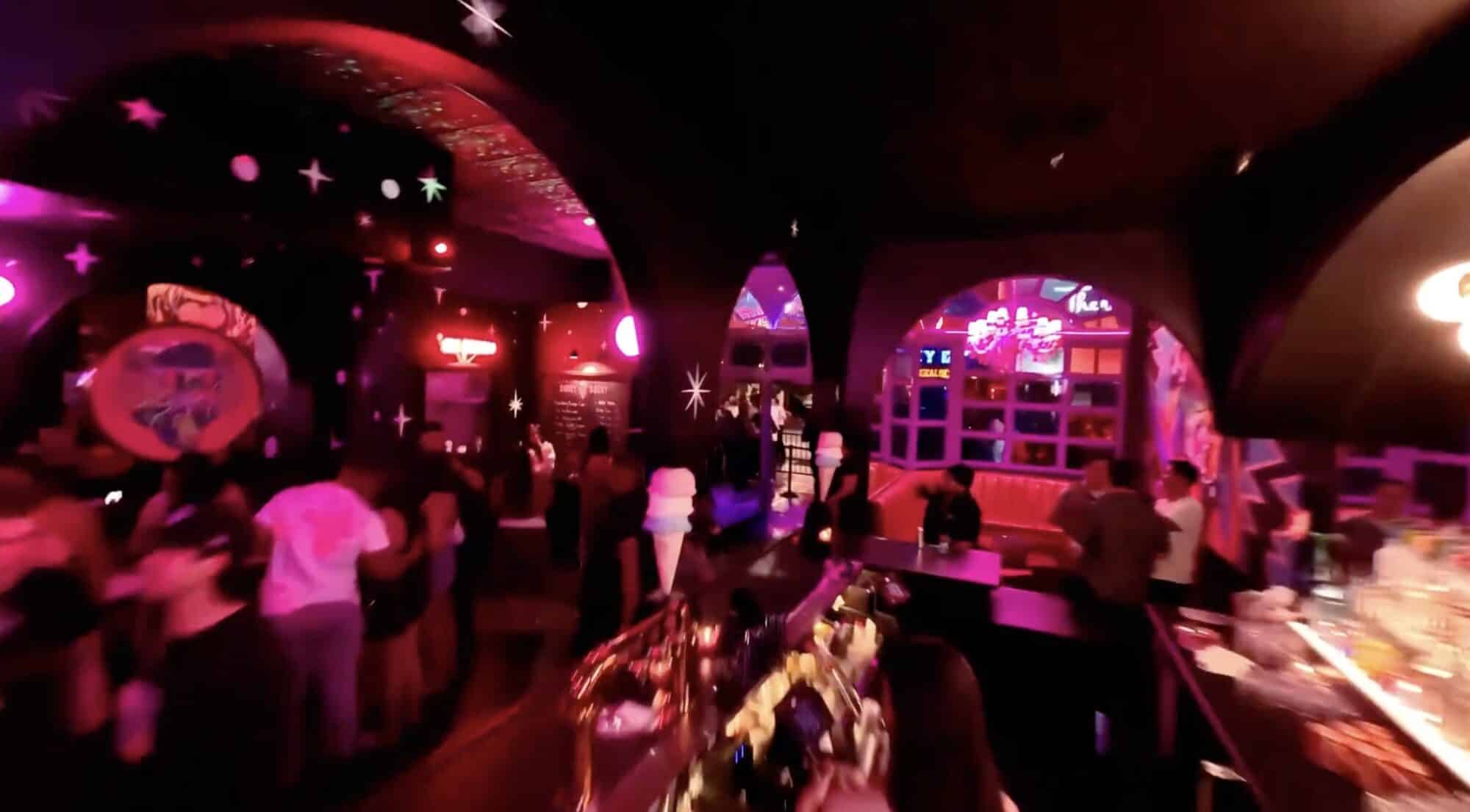 FPV frame sweeping through a neon-lit Las Vegas nightclub crowd.