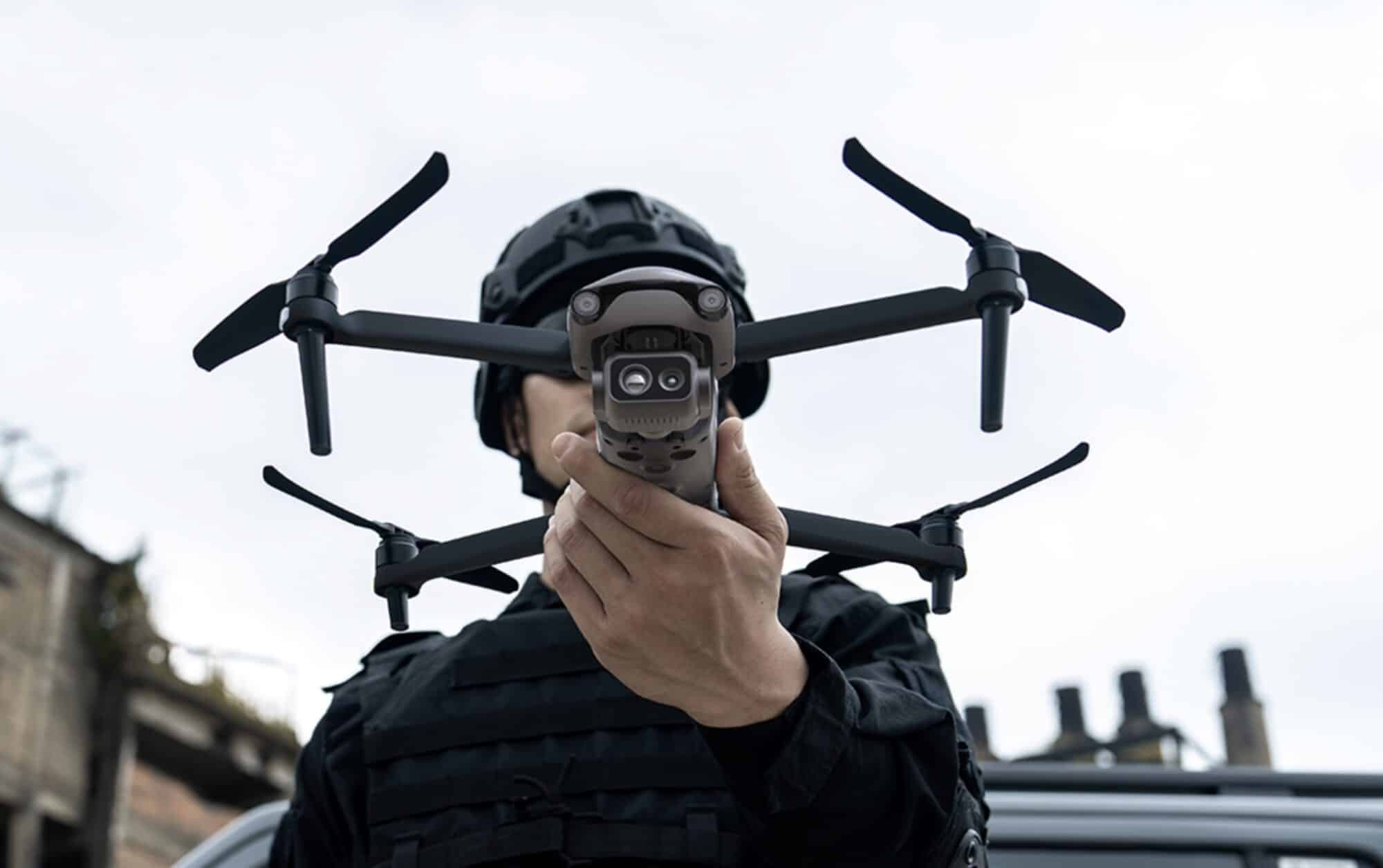 An officer in tactical gear holds an Autel EVO Lite Enterprise drone aloft.