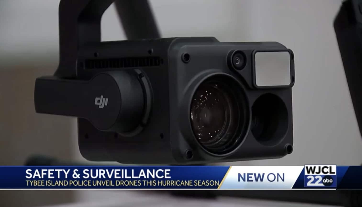 Close-up of a DJI zoom camera payload under a police drone during a news segment.