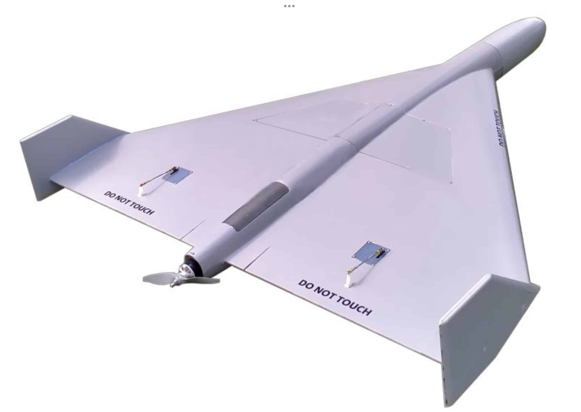 White delta-wing loitering munition with a nose propeller and Do Not Touch markings.