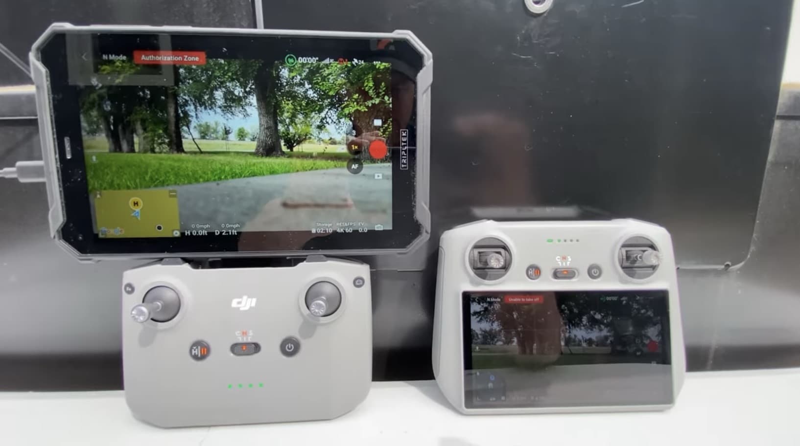Phone in a sun hood on an RC-N controller beside a DJI RC 2.
