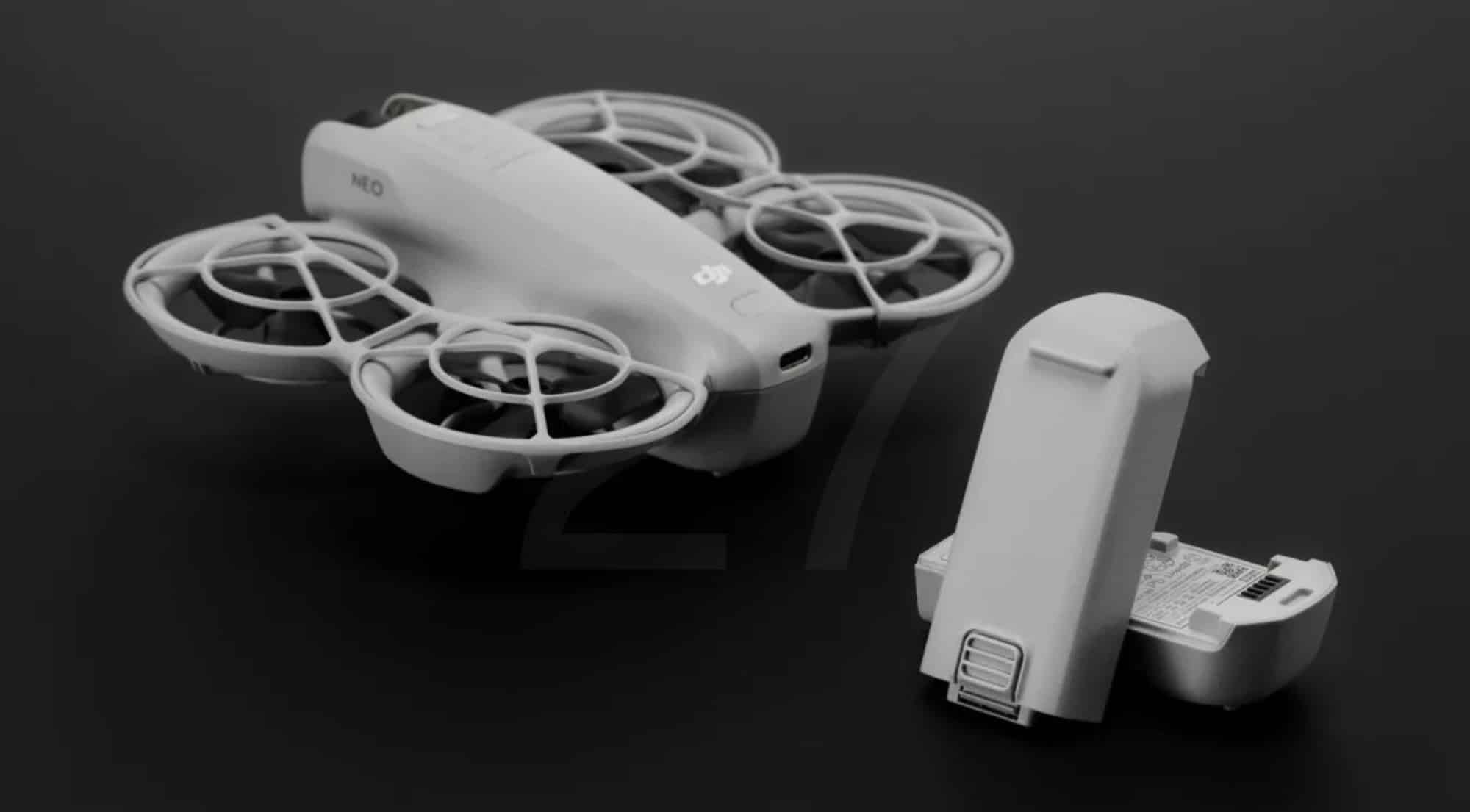 DJI Neo on a dark surface beside its swappable flight battery.