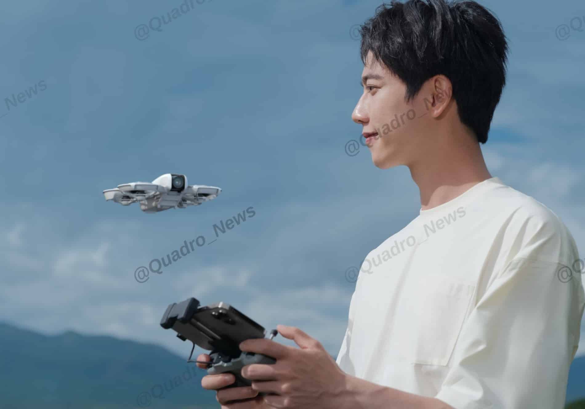 Man flying the white DJI Neo with a hand controller beside a mountain lake.