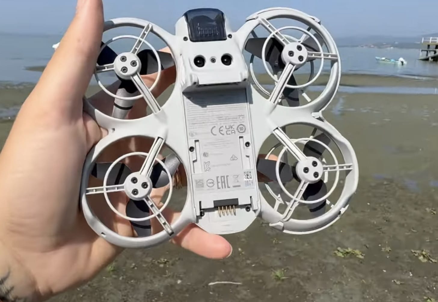 Underside of the DJI Neo with the battery lifted out of its bay.
