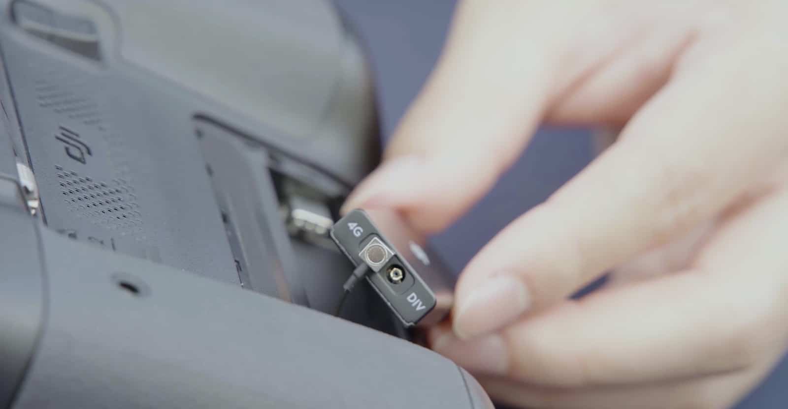 Close view of the dongle held with its 4G label facing the camera.