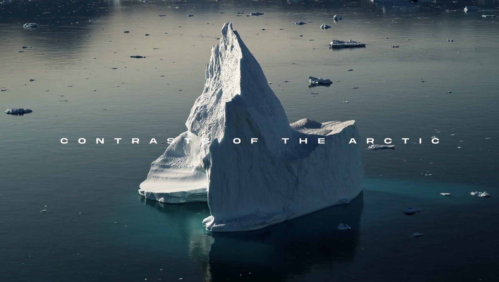 Jagged iceberg in dark Arctic water under the film title Contrasts of the Arctic.